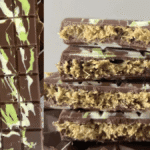Close up of a sliced homemade Quick-Pistachio-Chocolate-Bar-Happy-Treat showing its green pistachio and crunchy golden vermicelli filling, resting on a light grey quartz countertop under natural light.